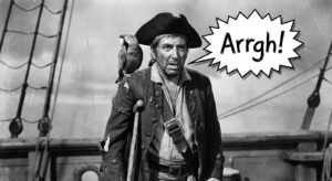 A black-and-white photo of Robert Newton as Long John Silver from the 1950 movie, with a speech bubble saying "Arrgh!".