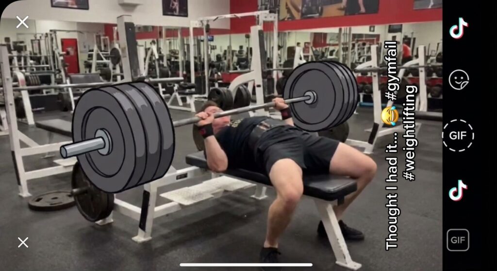 A funny gym fail GIF. Someone trying to lift a very heavy weight and failing spectacularly. The kind of GIF you'd see on TikTok or Instagram Reels.